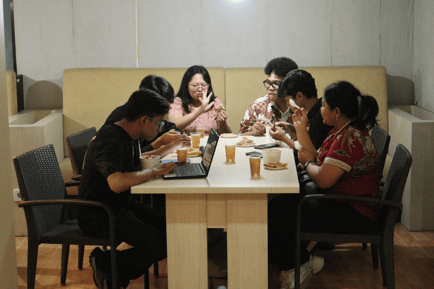 Peserta dialog dosen dan mahasiswa menikmati makanan bersama di meja makan