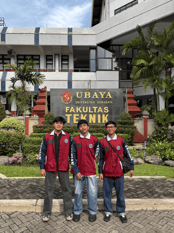 Tiga mahasiswa mengenakan jaket baru di depan papan nama Fakultas Teknik sambil Menyambut Hadirnya Jaket Teusian